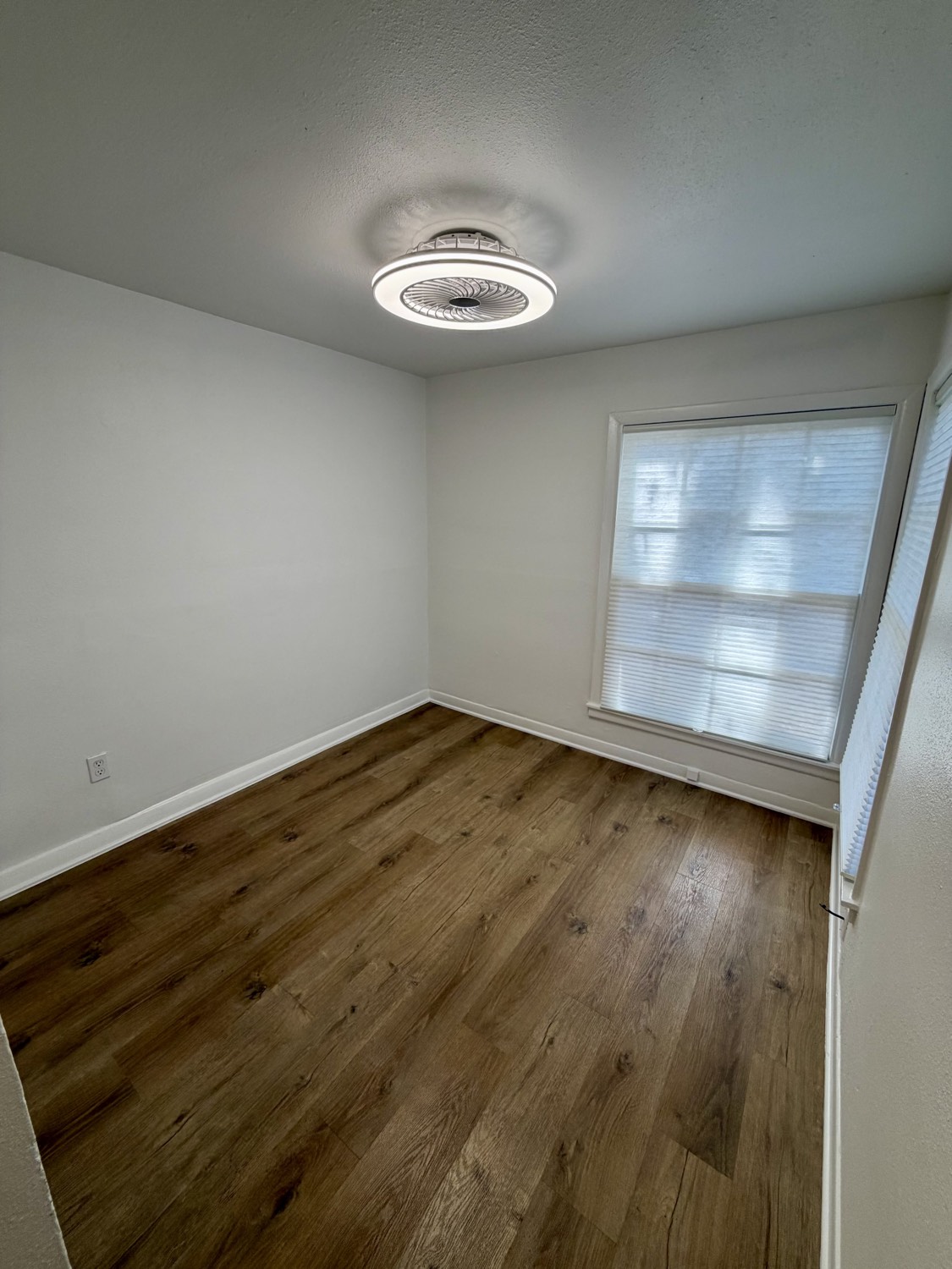 Bright bedroom with ceiling fan light and large window