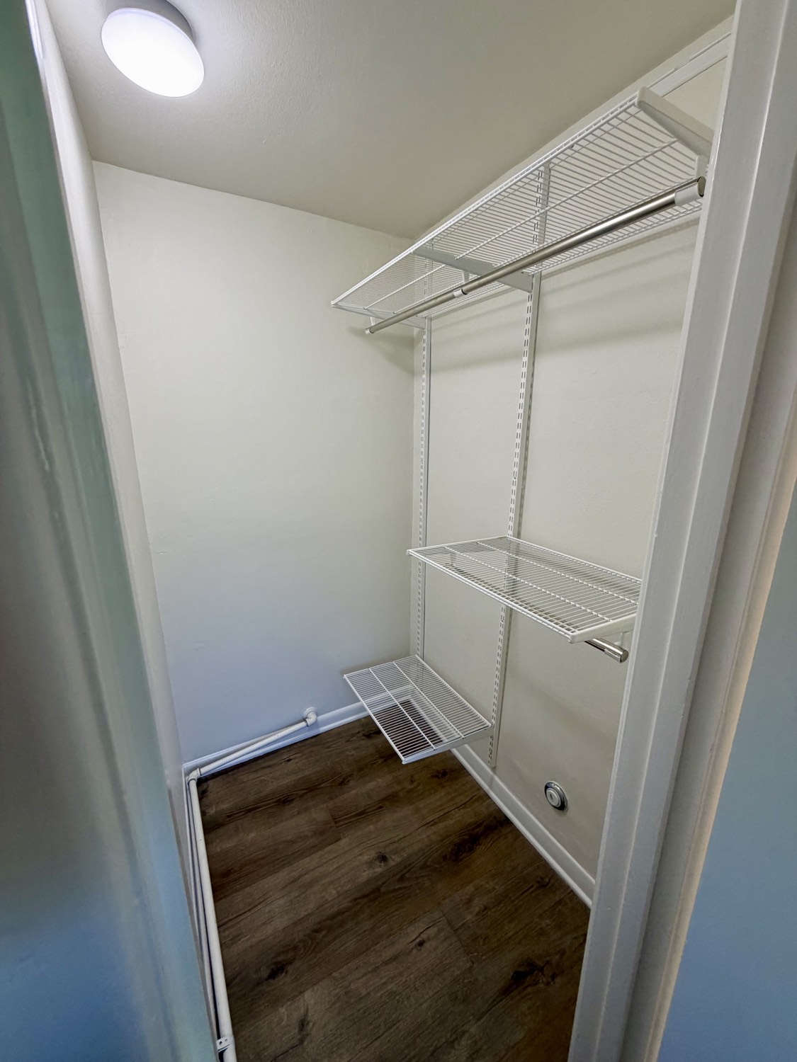 Walk-in closet with new white wire shelving