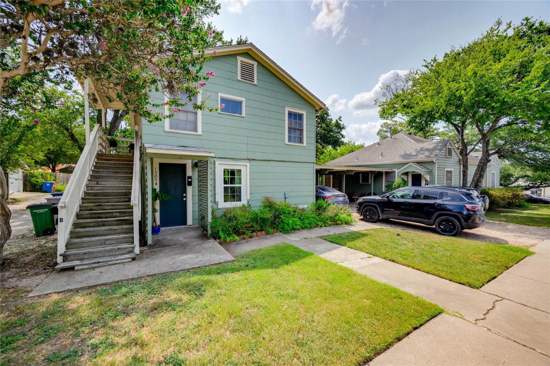 Front exterior of 1505 W. 12th Street, Unit A, a green two-story home in Historic Clarksville, Austin