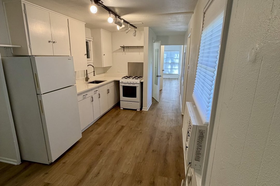 Kitchen in Unit C showing gas range, refrigerator and sink from the hallway