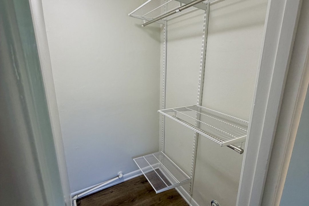 Walk-in closet in Unit C with new white wire shelving for maximum storage