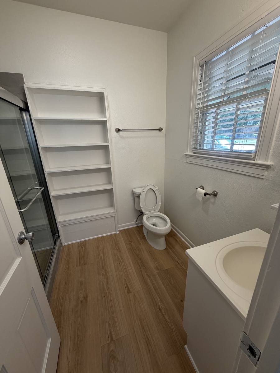 Bathroom vanity, built-in linen shelving and window in Unit D